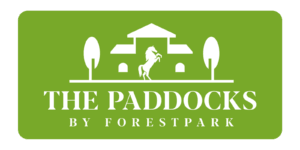 Official green corporate logo for The Paddocks by ForestPark featuring a white silhouette of a rearing horse and estate.